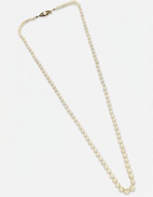 un collier de perles blanches avec un fermoir en or