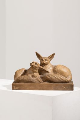 sculpture représentant un chat et un chien allongés sur une surface blanche