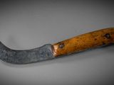 a close up of a knife with a wooden handle on a table
