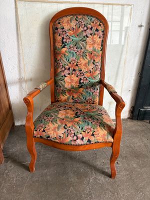 an old wooden chair with a floral upholstered seat
