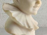 marble bust of a boy with a collar on a white background