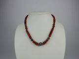 a close up of a necklace on a mannequin with red beads