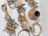 a lot of brass musical instruments on a white surface