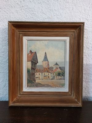 framed picture of a painting of a village with a church in the background