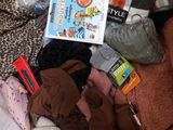 a pile of clothes and other items on a bed
