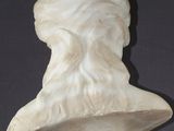 marble bust of a man with a beard and a hat on a stand