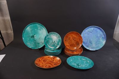 many different colored plates sitting on a black table