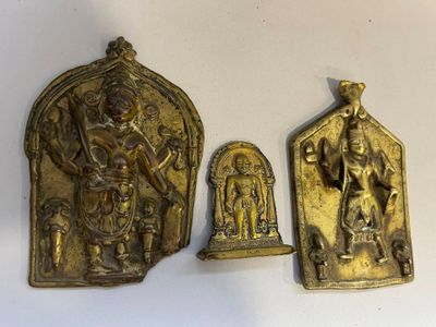 trois figurines en laiton représentant des divinités hindoues, posées sur un fond blanc