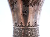 a silver vase that is sitting on top of a table