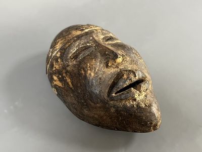 gros plan d'un masque en bois sur une surface blanche