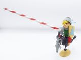 toy figurine of a man riding a bicycle with a red and white striped pole