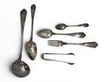 five spoons and a fork on a white surface