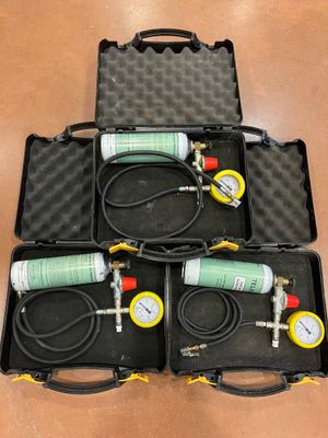 three air compressors in a case with hoses and gauges