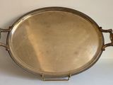 un plat ancien en argent, muni de poignées, sur un fond blanc