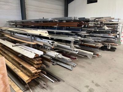 de nombreuses pièces de bois empilées sur le sol d'un entrepôt