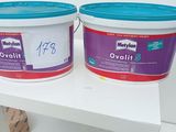 two buckets of paint sitting on a white table