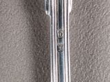 a silver spoon with a flower on it sitting on a table