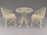 a set of three wrought iron chairs and a table