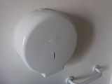 a toilet paper dispenser on the wall in the bathroom