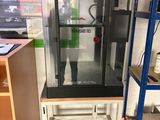 une image représentant un homme debout devant une imprimante 3D