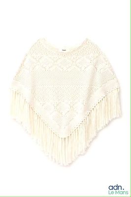 un gros plan sur un ponche blanc orné de franges