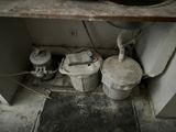 a dirty bathroom with a sink and a trash can