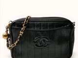 un sac Chanel noir avec une chaîne autour de la bandoulière