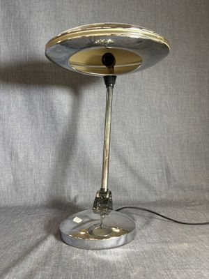 une photo d'une lampe de table avec un pied argenté et un cordon noir
