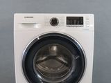 a close up of a white washing machine on a gray surface