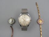 Deux montres et un bracelet sont posés sur une table