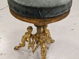 an image of a gold stool with a blue cushion on it