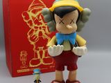une petite figurine représentant un personnage de dessin animé à côté d'une boîte rouge