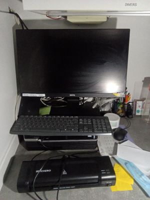 un ordinateur portable posé sur un bureau à côté d'une imprimante