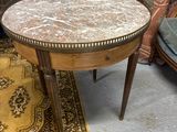 une petite table avec un plateau en marbre posée sur un tapis