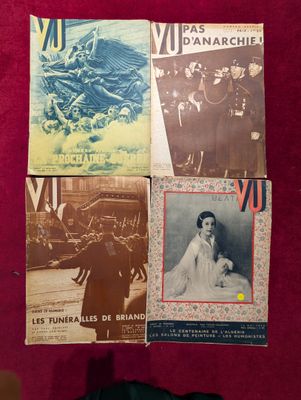 Plusieurs vieux magazines français sont exposés sur un support rouge