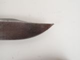 a knife that is on the table next to a piece of paper
