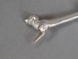 a metal object that looks like a bird on a branch