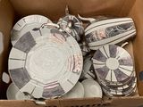 many plates and bowls in a box on the floor
