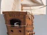 a wooden model of a boat with a bird inside of it
