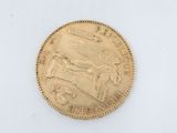 a close up of a gold coin on a white surface