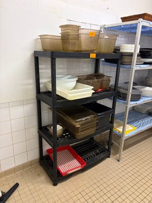 une étagère noire sur laquelle sont posés des plats, dans une cuisine