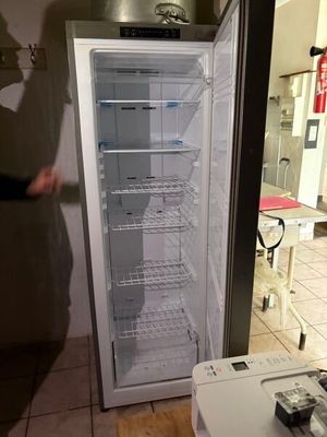 un homme debout à côté d'un réfrigérateur ouvert dans une cuisine