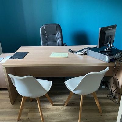 un bureau avec deux chaises et un ordinateur dessus