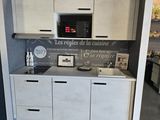 a kitchen with a microwave, oven, cabinets, and pictures on the wall