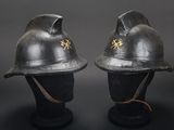 two black helmets with gold stars on them sitting on a black surface