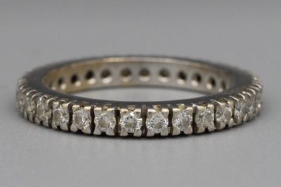 Gros plan sur une bague « éternité » sertie de diamants posée sur une table