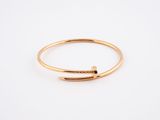 a gold ring with a curved bar on top of it