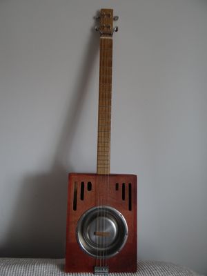 a guitar sitting on top of a table next to a speaker