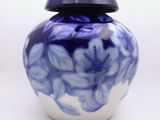 un vase bleu et blanc avec un couvercle sur une table