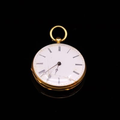 a gold pocket watch with roman numerals on the face